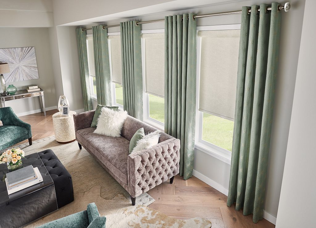 Custom drapes and roller shades filtering soft light in a living room