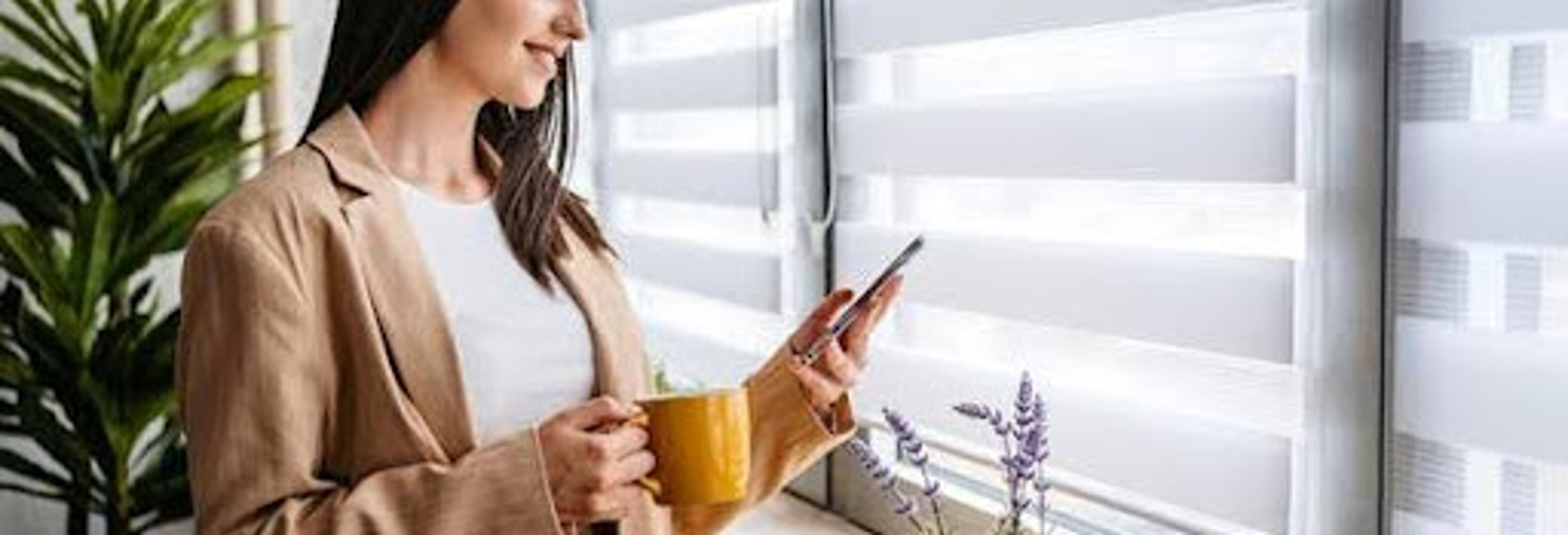 Woman using her mobile phone while in front of the window | Gotcha Covered