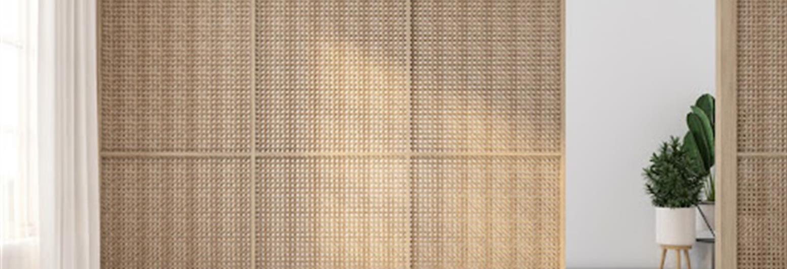 Light-filtering woven wood panels in a bright room with a potted plant, showcasing biophilic interior design. | Gotcha Covered